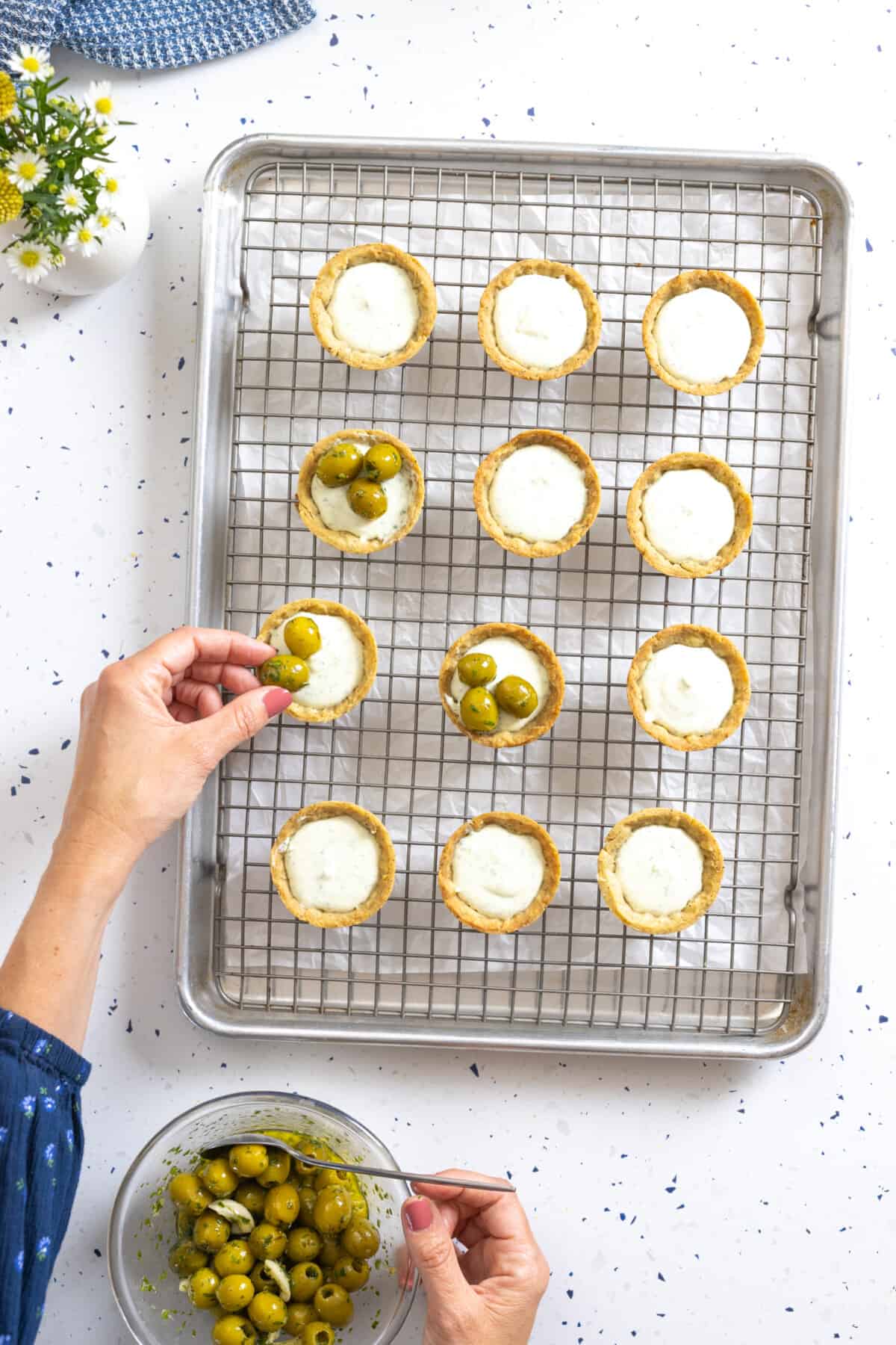 Topping Goat Cheese Tartlets with green olives