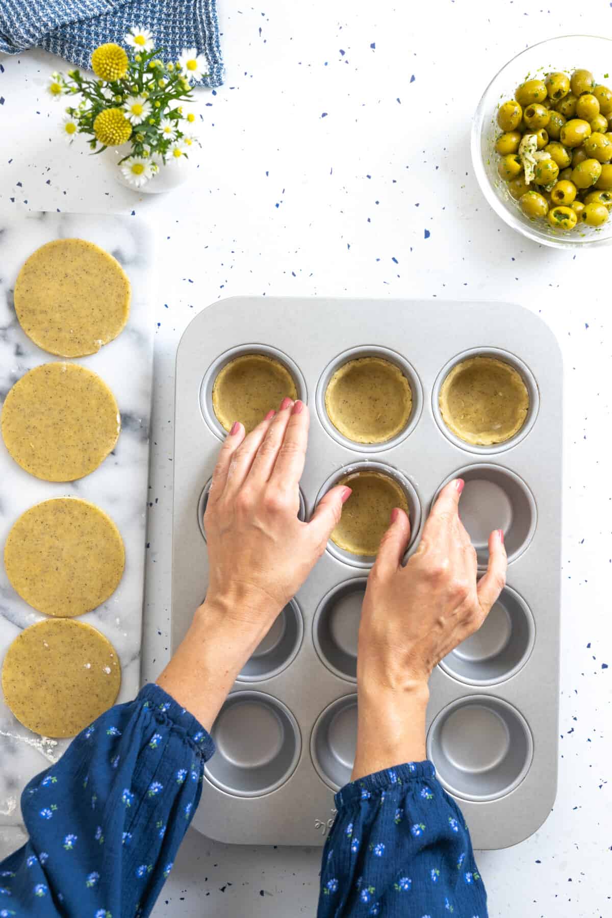 pressing savory tartlet dough into muffin pan