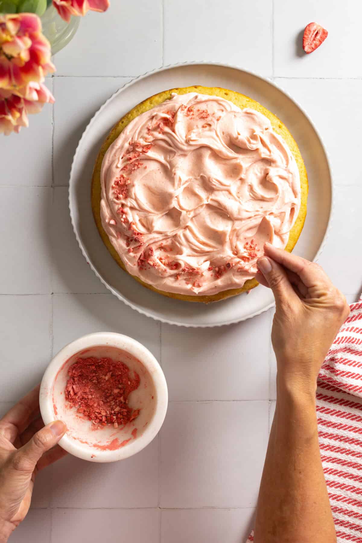 Sprinkling freeze dried strawberries on Pink Cake