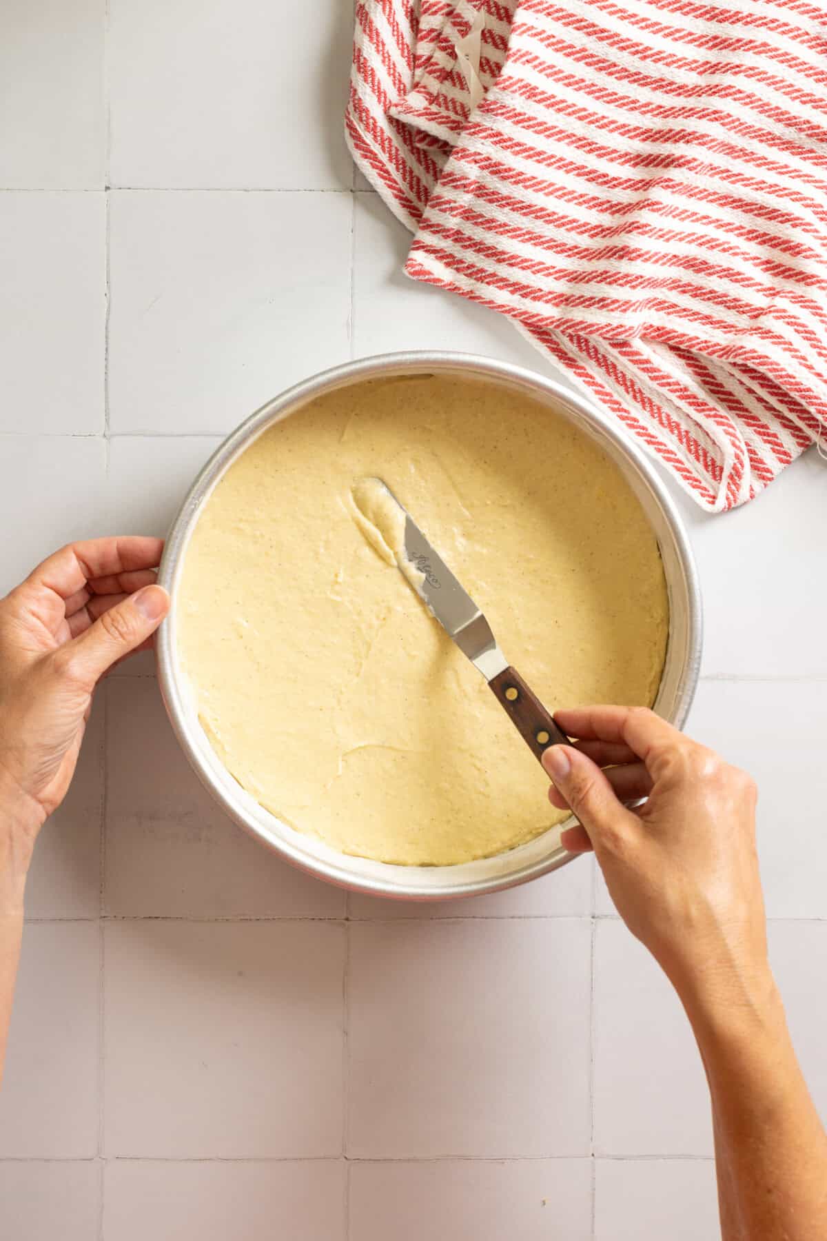 adding cake batter to cake pan