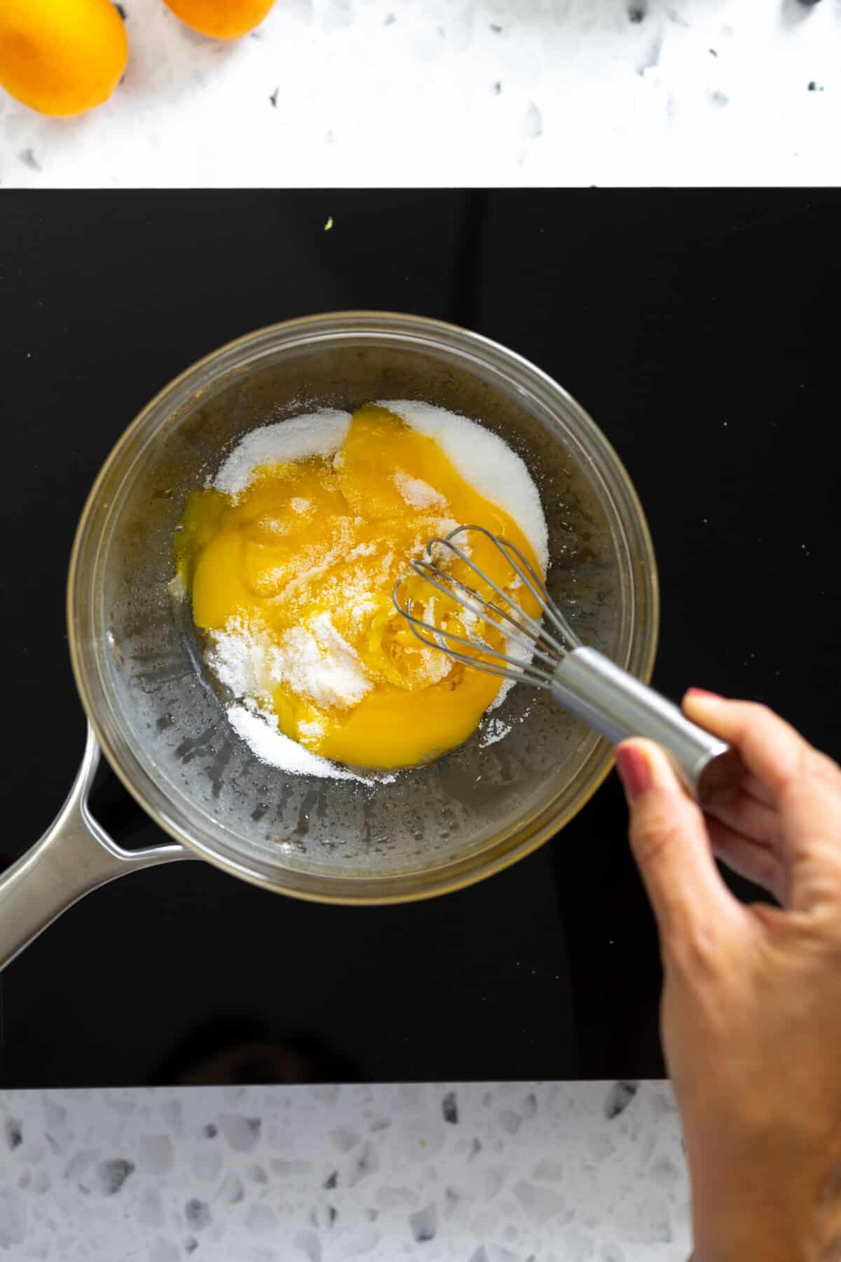 whisking egg yolks and sugar in double boiler
