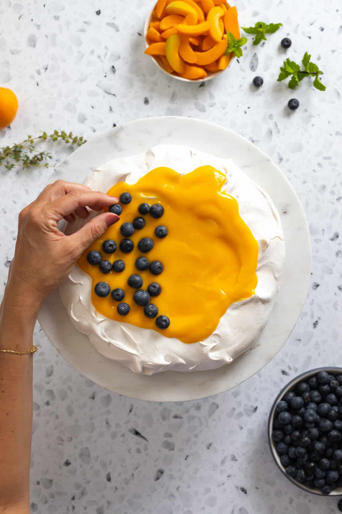 Adding blueberries to Pavlova