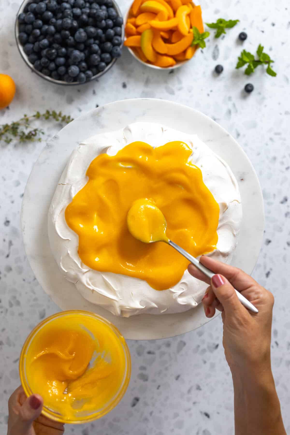 Adding Apricot Curd to Pavlova