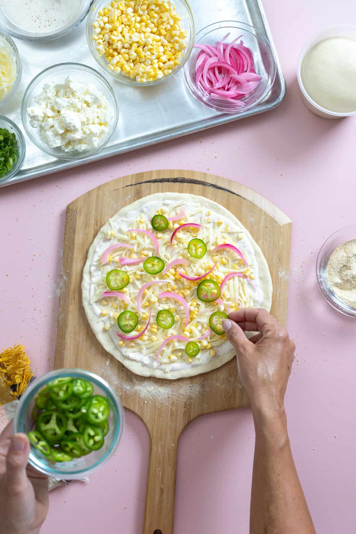 putting jalapenos on pizza