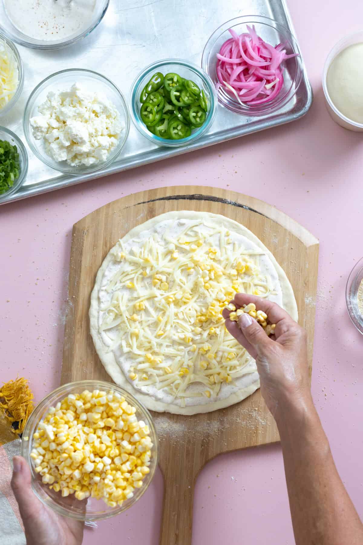 Adding corn to Elota Pizza