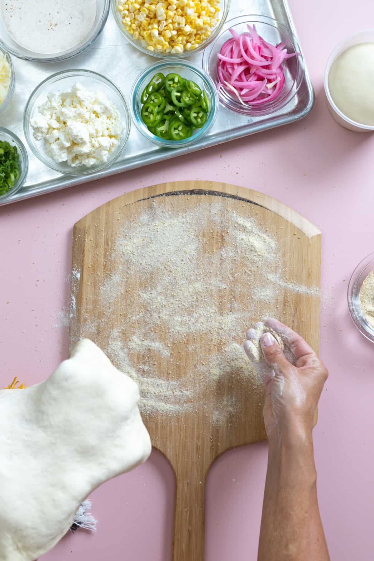adding semolina flour under pizza dough