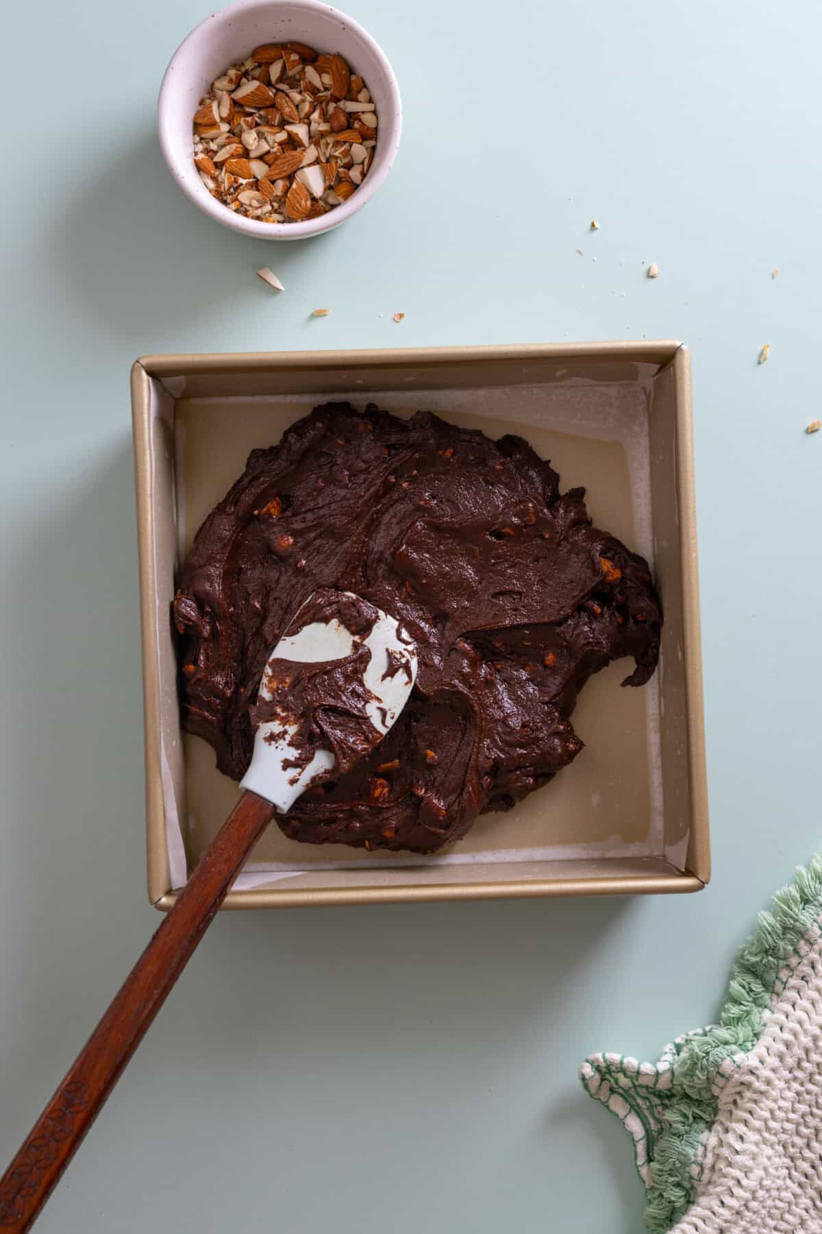 adding brownie batter to pan