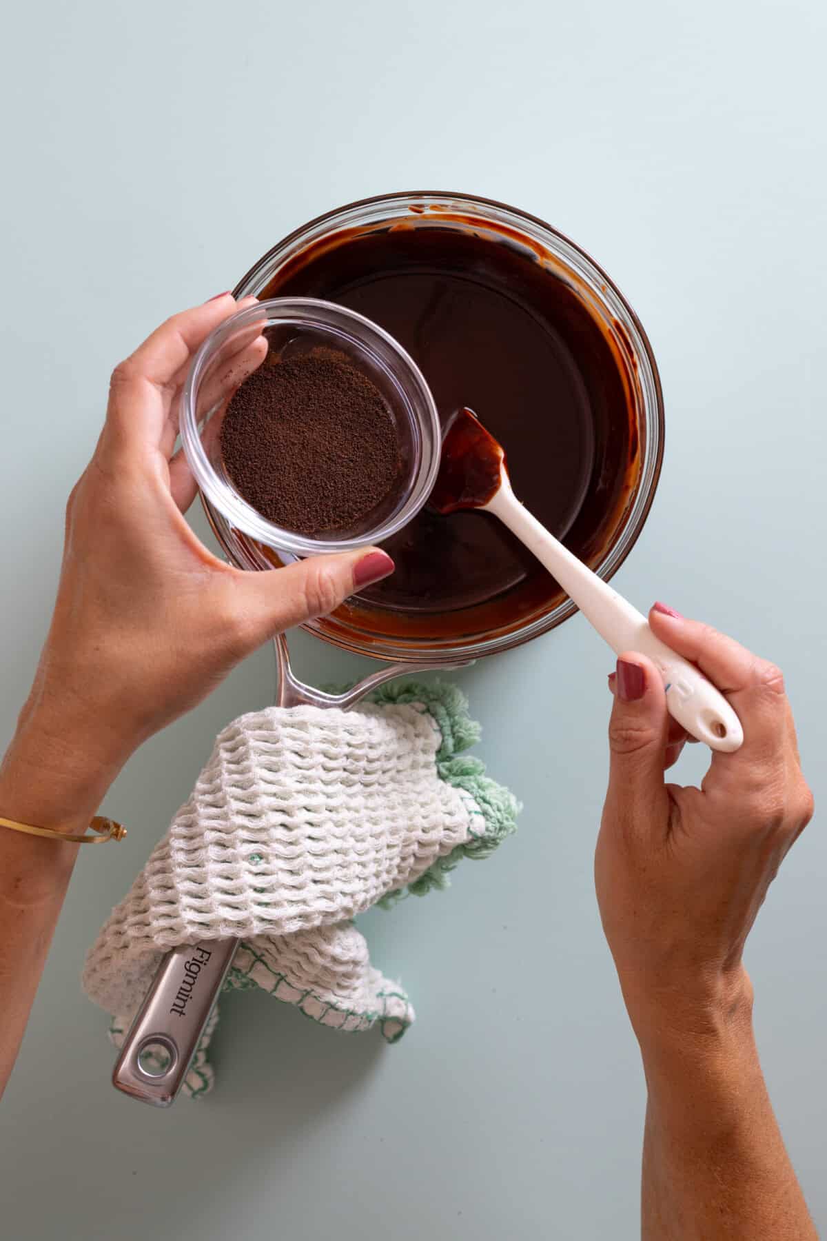 adding espresso powder to melted chocolate and butter for brownies