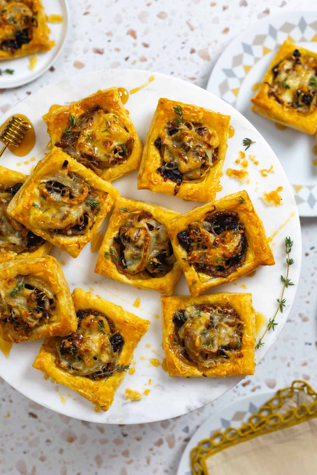 Prune Onion Fontina Tarts on decorative plates, shot from above