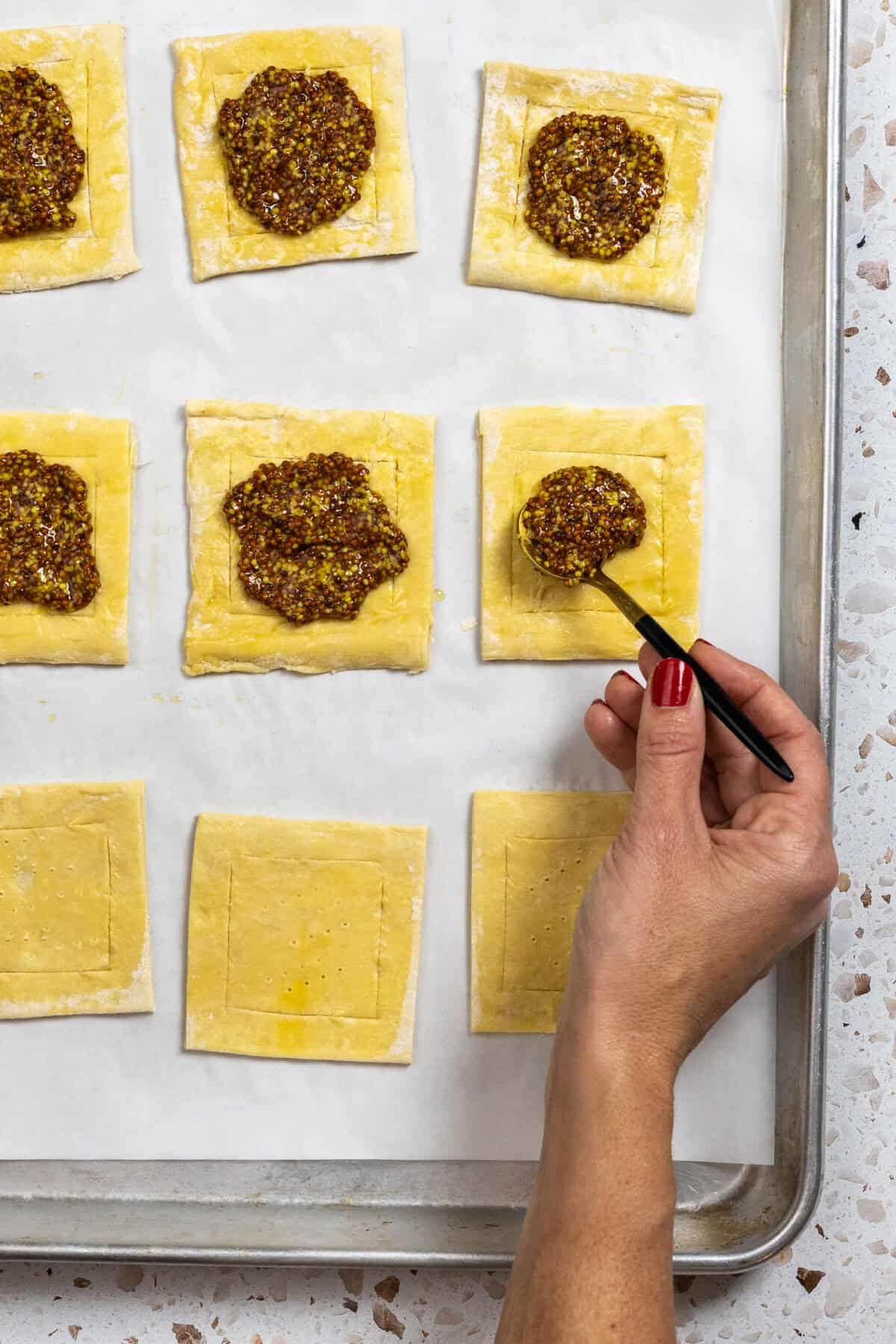 topping puff pastry with mustard
