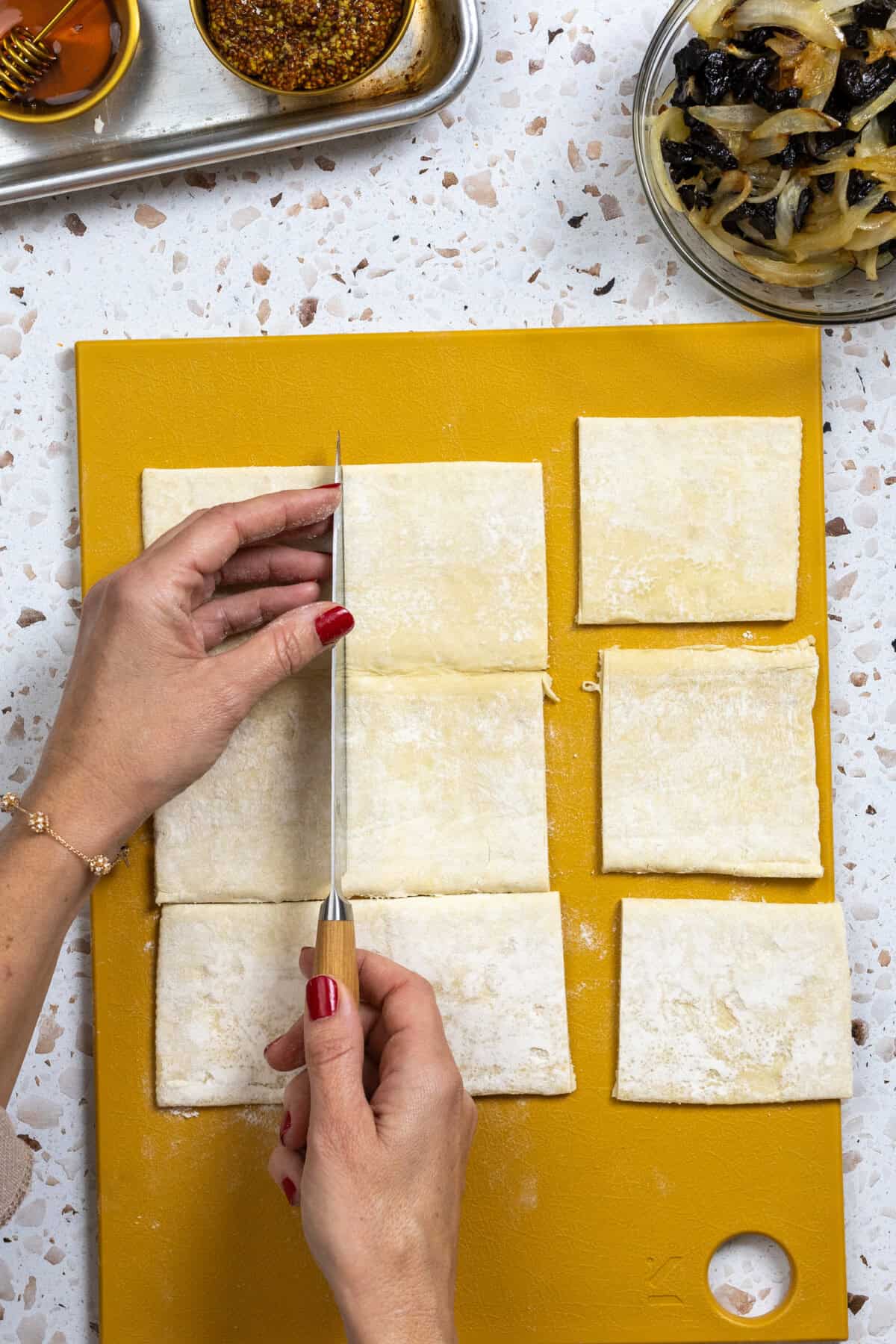 slicing a puff pastry sheet into squares