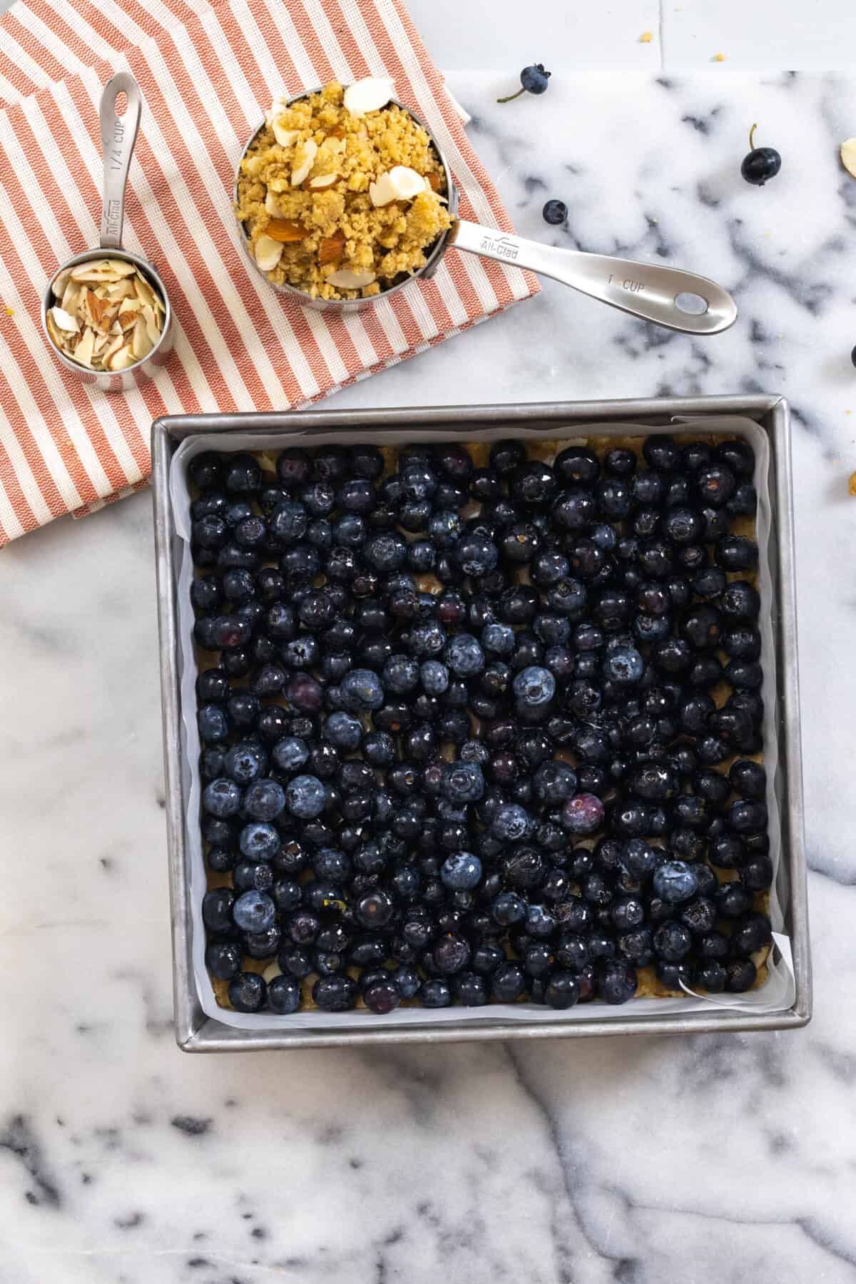 topping bottom crust with blueberries