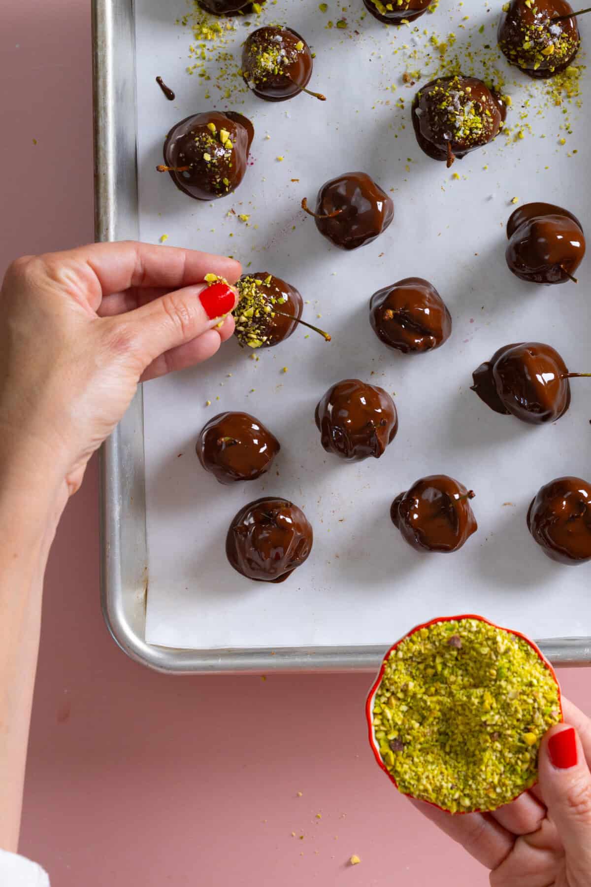 Sprinkling pistachios on Chocolate Prune Cherry Bombs
