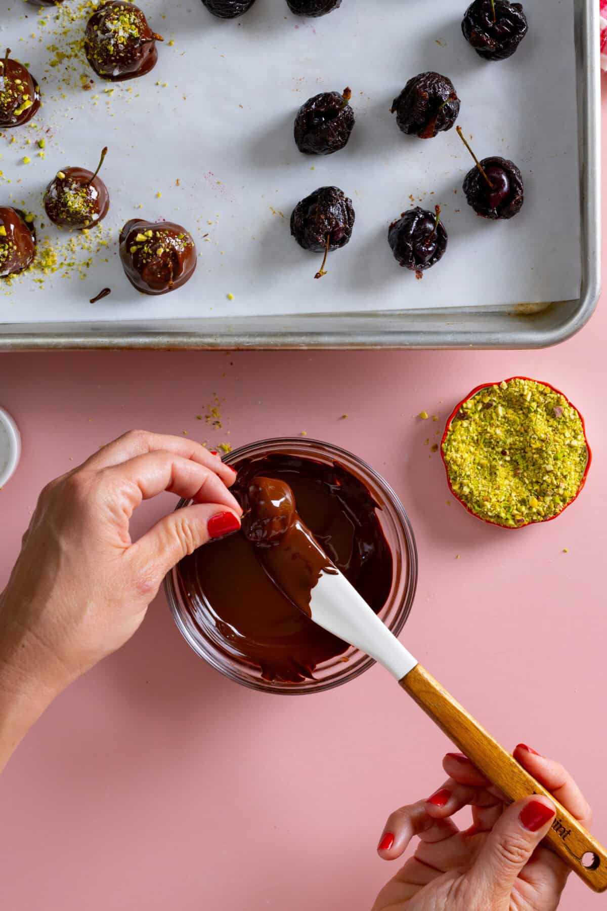 Dipping Chocolate Prune Cherry Bombs in melted chocolate