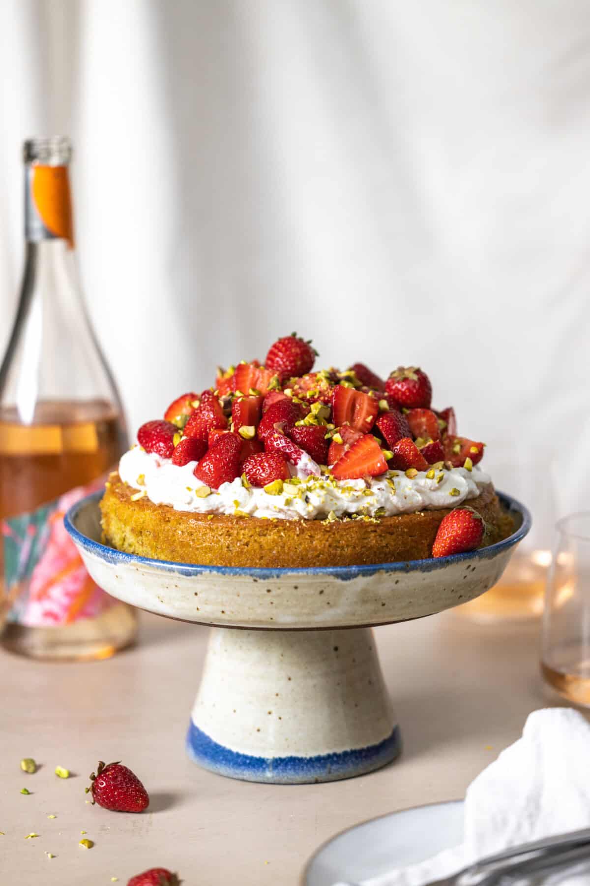 Strawberry Pistachio Olive Oil Cake on a pedestal