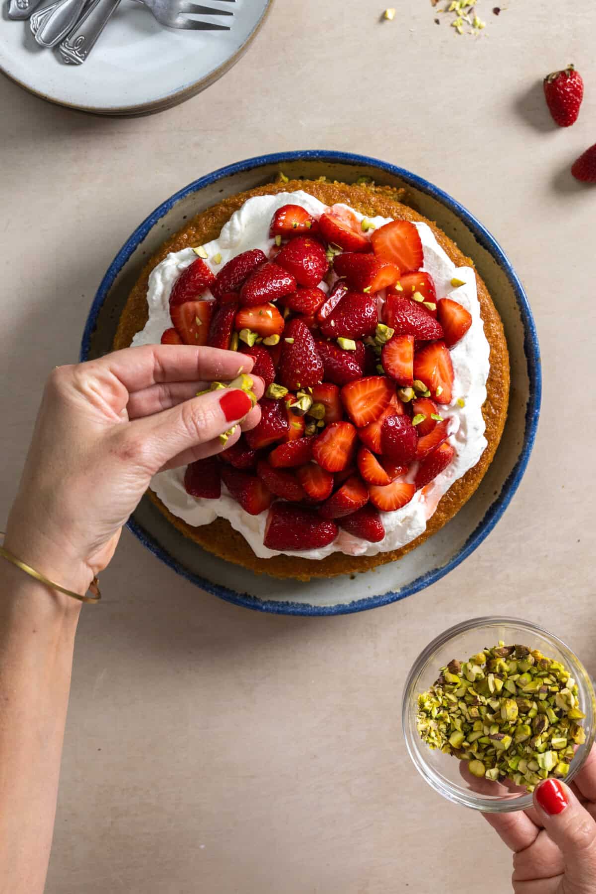 sprinkling chopped pistachios on cake
