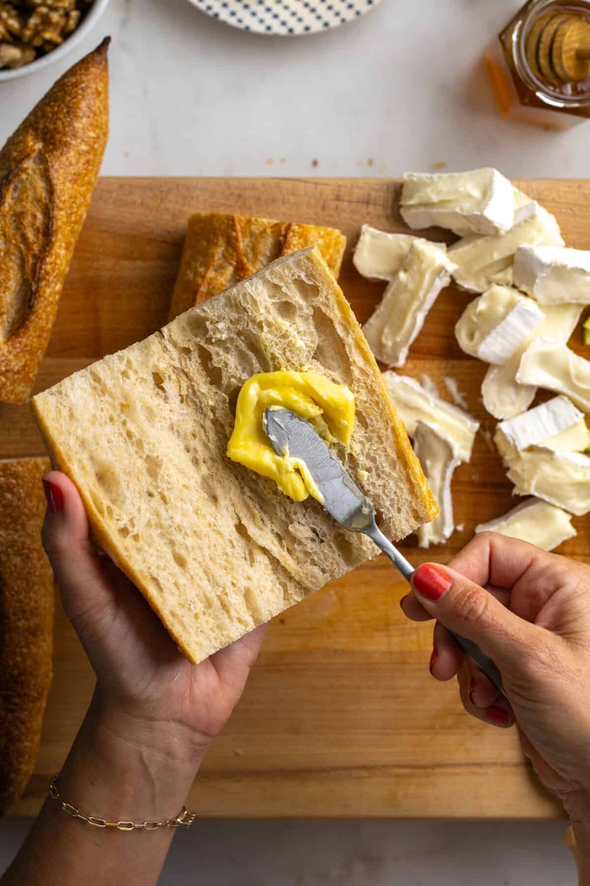 Spreading butter on baguettes.