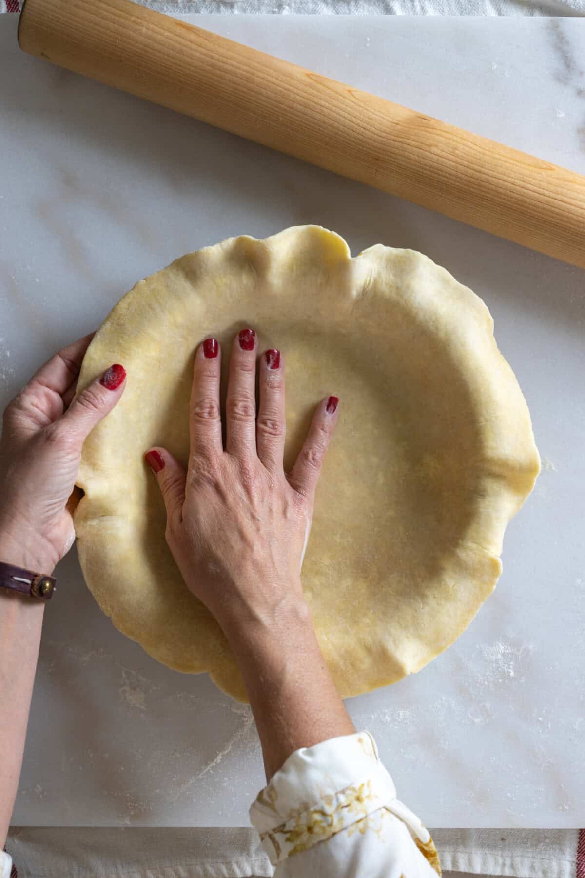Tucking pie dough into pie dish