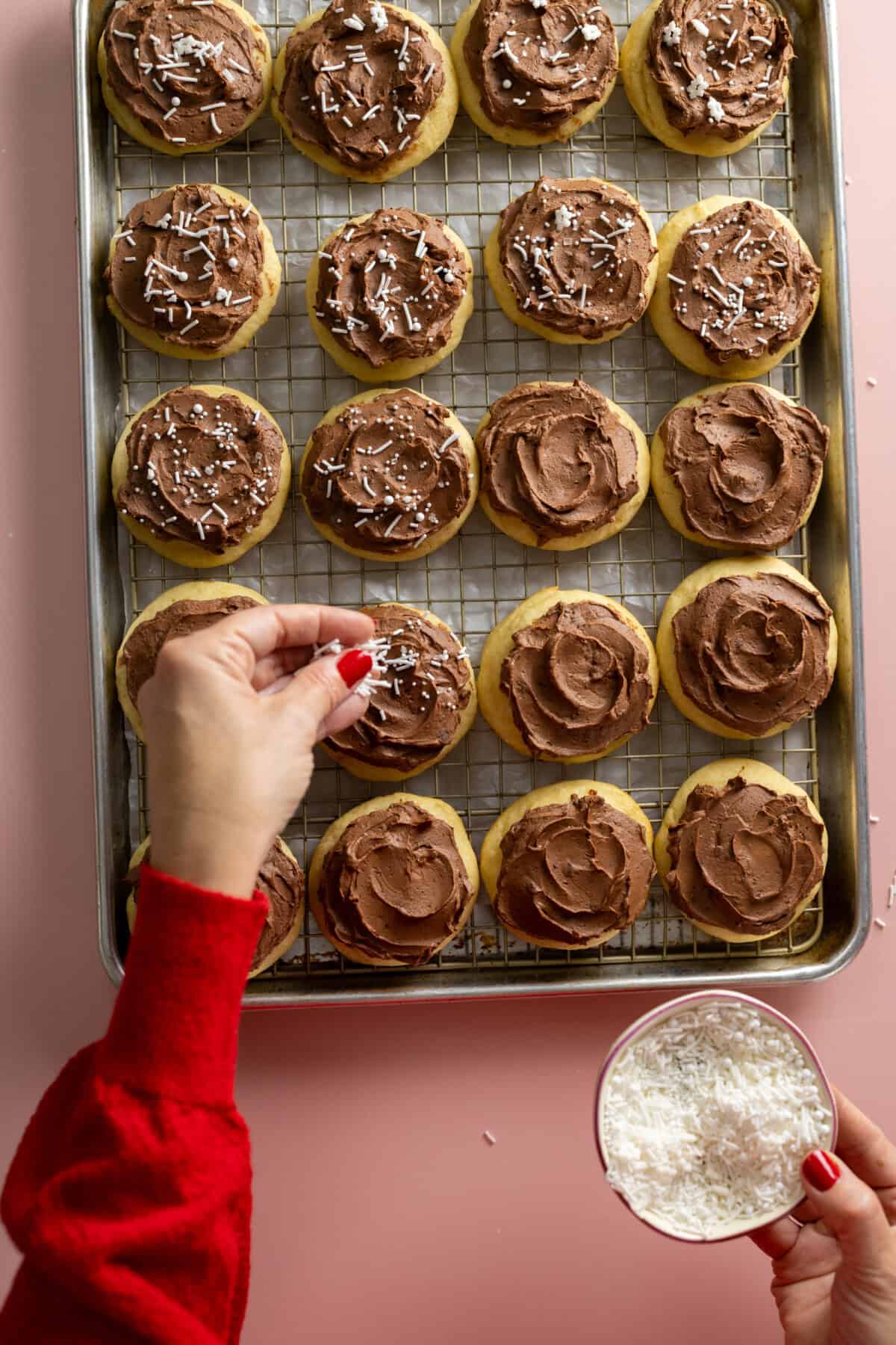 Adding sprinkles to Sour Cream Cookies with Chocolate Frosting