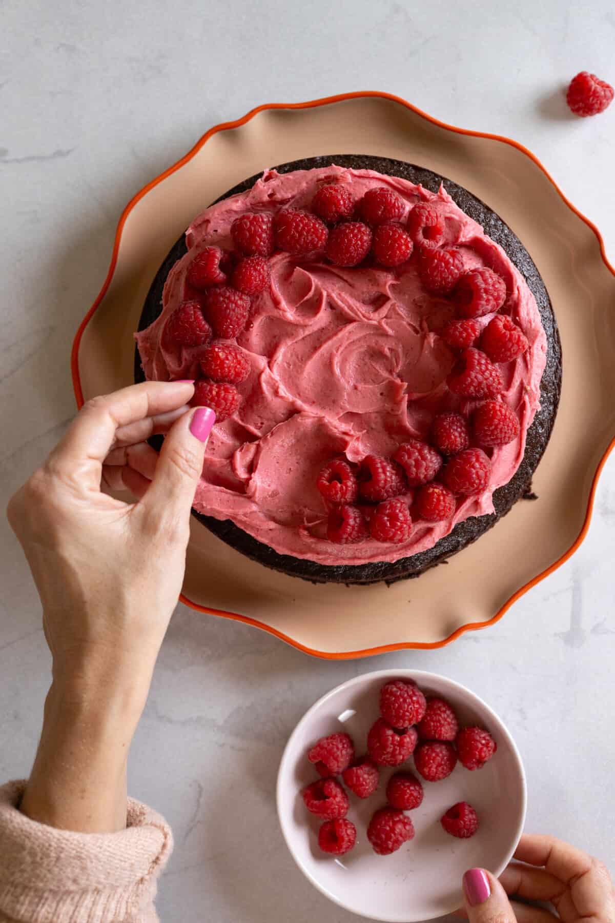 Decorating the Chocolate Raspberry Cake with raspberries