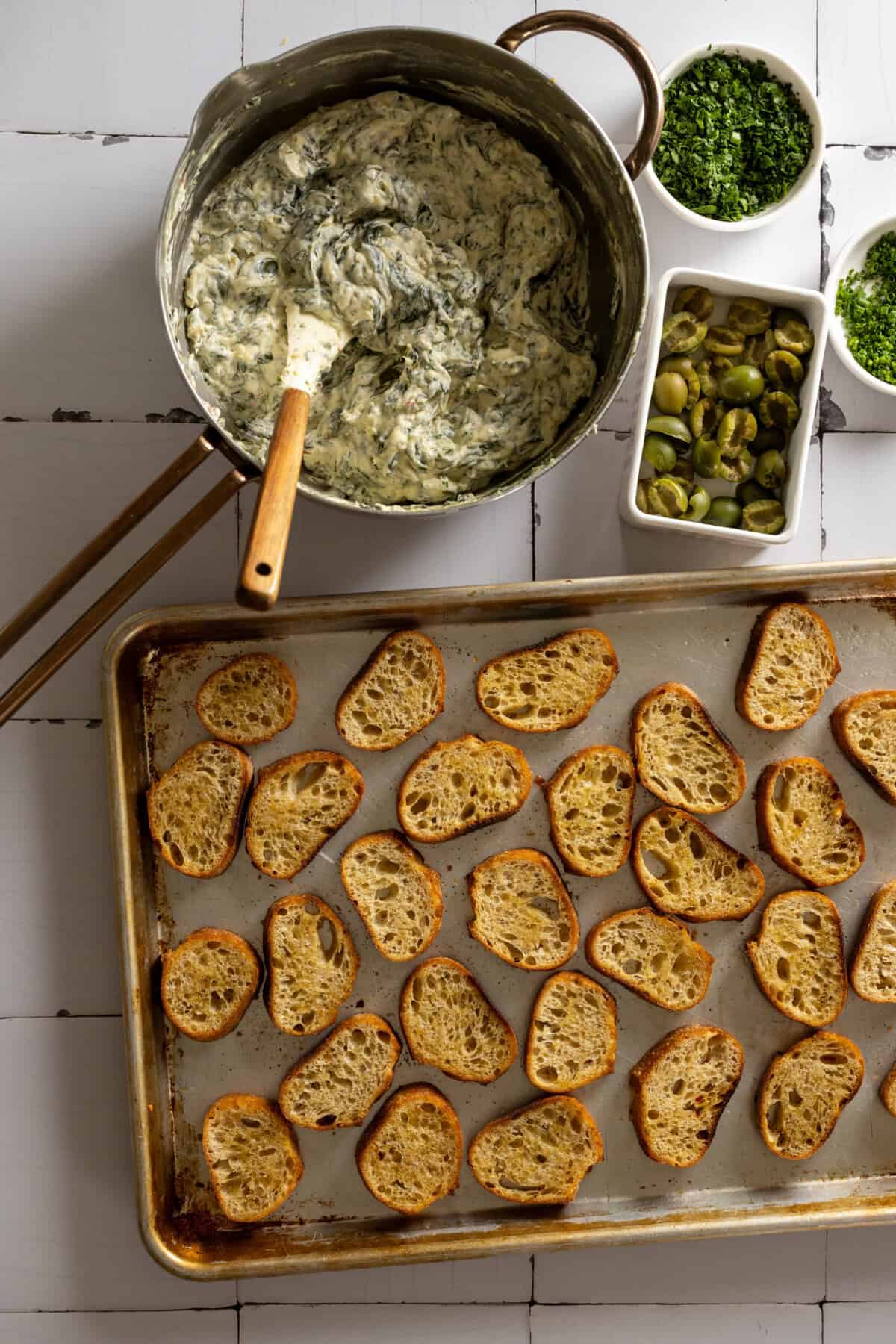 Assembling Spinach Olive Dip Crostini