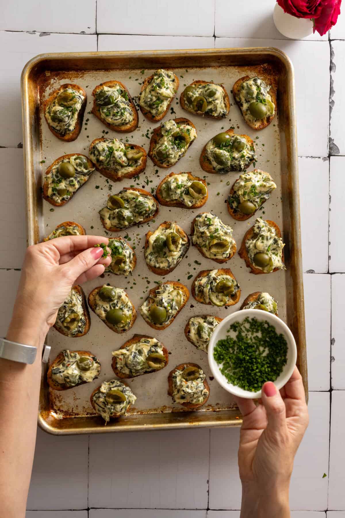 Topping Spinach Olive Dip Crostini with herbs
