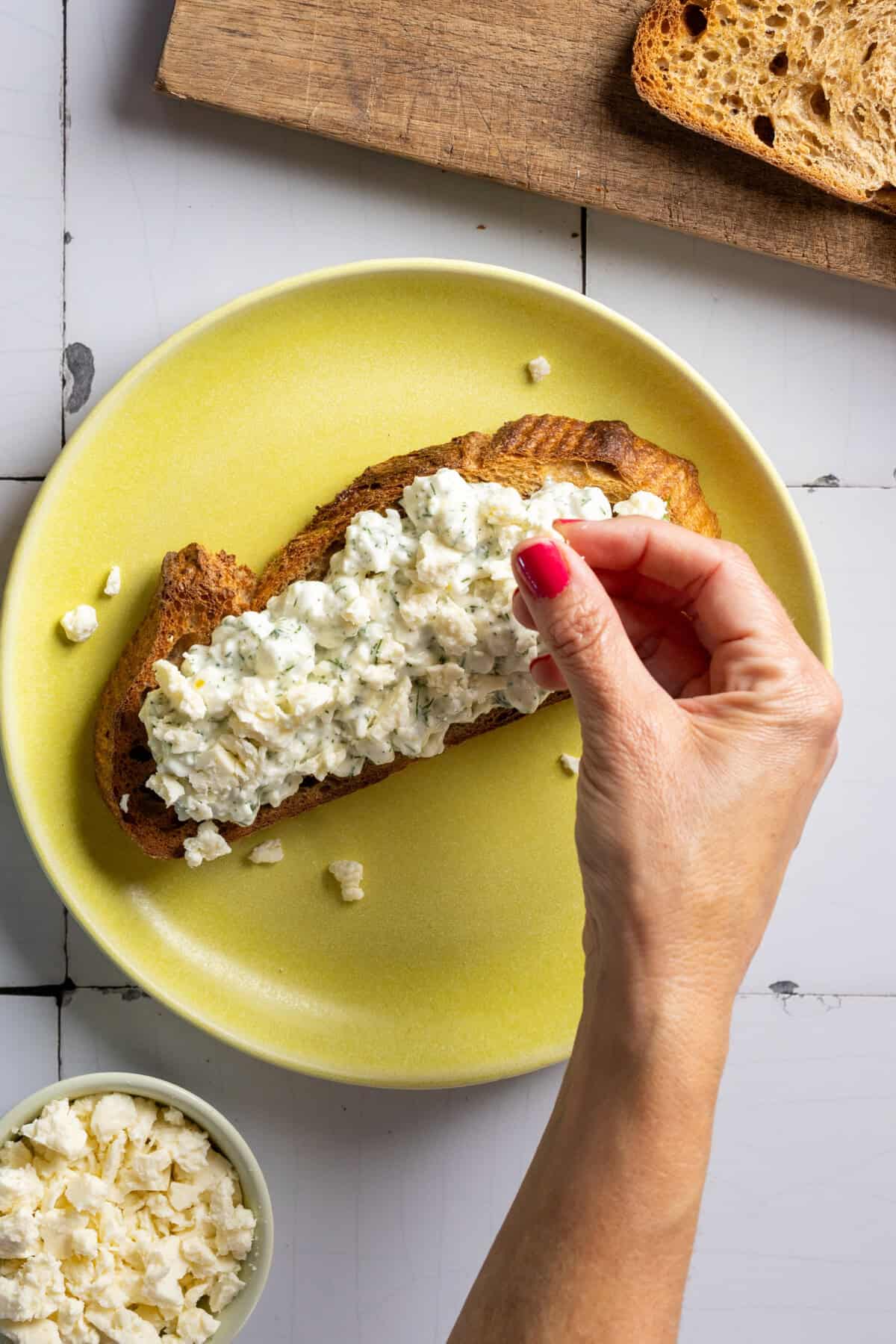 Adding feta to Tzatziki Toast
